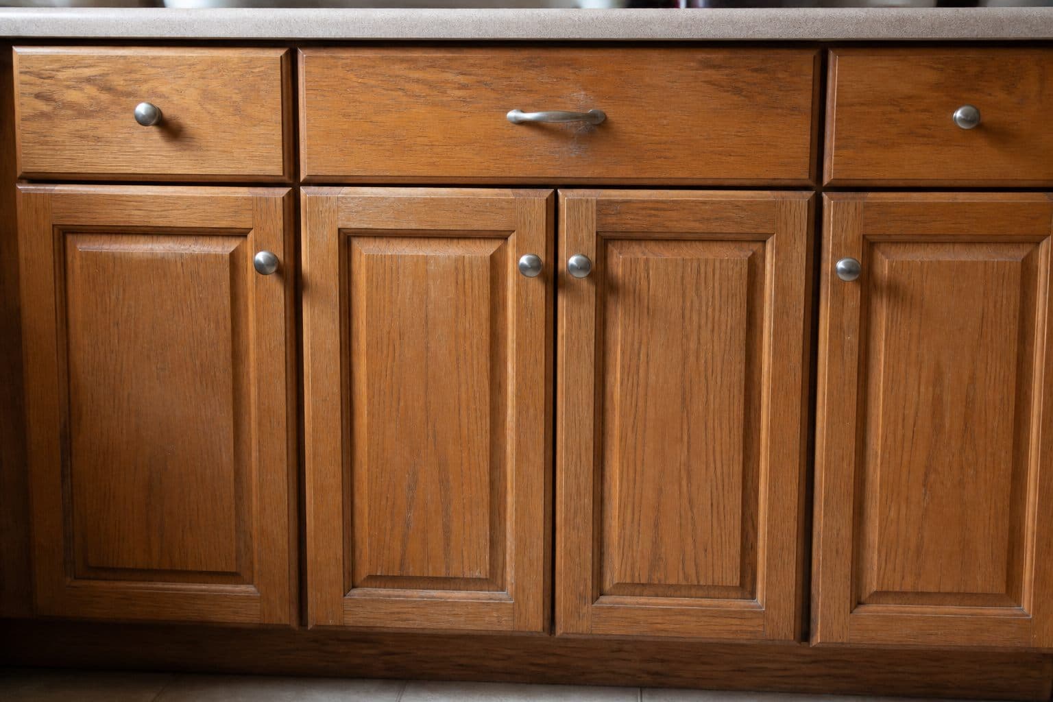 Kitchen cabinets with worn finish before refinishing